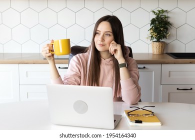 Woman Takes A Break From Work And Drinks Tea, Online Work At A Laptop. High Quality Photo