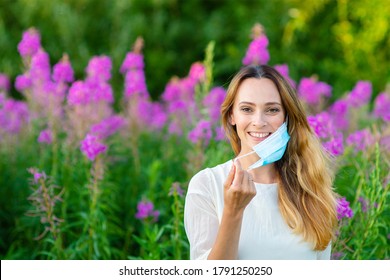 The woman takes off her medical mask and rejoices. End of quarantine concept. End of the coronavirus pandemic. Recovering from allergies concept - Powered by Shutterstock