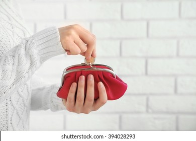 Woman Takes Out Money From A Red Wallet