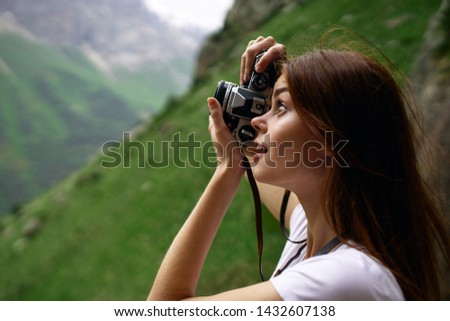 woman takes pictures of nature in the mountains