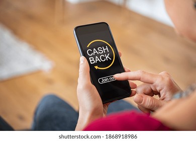 Woman Taking Benefit Of Cash Back Using Smart Phone, Shopping And Money Refund Concept. Close Up Hand Holding Smartphone With Button To Get Started The Cashback. 