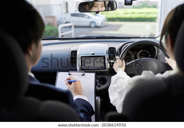 A woman taking a car\
driving lesson