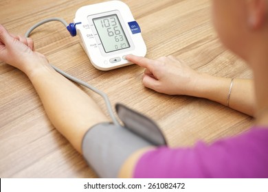 Woman is taking care for health with hearth beat monitor and blood pressure