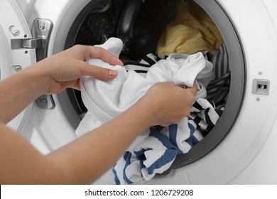Woman taking clothes out of washing machine, closeup. Laundry day