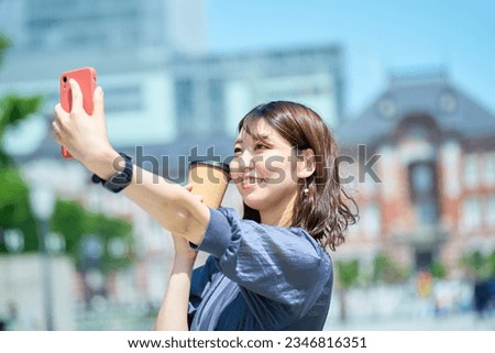 A woman taking a commemorative photo with a smartphone