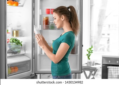 Woman taking food out of fridge at home - Powered by Shutterstock