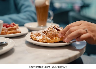 Woman Taking A Fresh Almond Croissant From A Plate