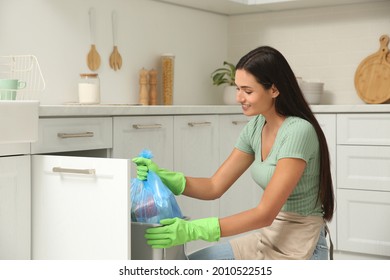 Woman Taking Garbage Bag Out Of Bin At Home