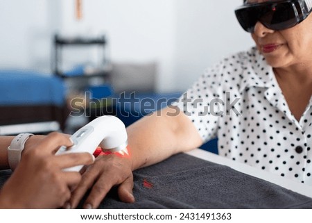 Woman taking infrared light treatment as arthritis treatment