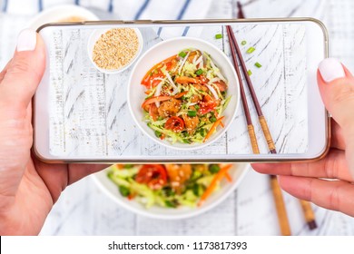 Woman Is Taking Mobile Photo Of Asian Salad With Salmon And Vegetables. Instagram Food Photography Concept