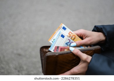 Woman is taking money from the purse - Shutterstock ID 2286278351