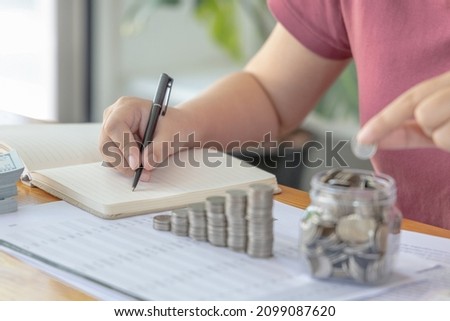 Woman are taking notes on household income and expenses and working to save money for future use, Money management for use when needed, Saving money for future growth and knowing how to manage money.