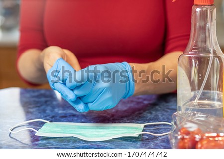 Woman is taking off disposable hygiene gloves from her hands closeup