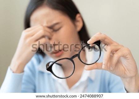 woman taking off glasses tired of computer work suffering from eye strain tension