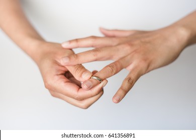 A Woman Is Taking Off Her Wedding Ring From Her Finger.