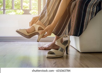 Woman Taking Off High Heels Shoes At Home