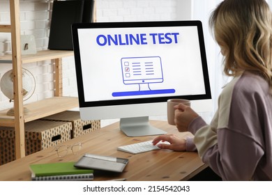 Woman Taking Online Test On Computer At Desk Indoors