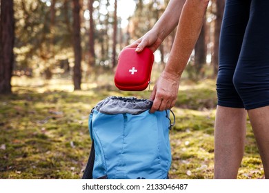 Woman Taking Out First Aid Kit From Backpack. Travel Insurance For All Eventualities. Prepared For Health Problems During Hiking