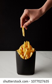 Woman Taking Out French Fry From Box Isolated On Black