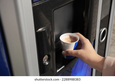 Mujer tomando taza de papel con café de la máquina expendedora, closet
