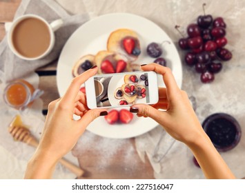 Woman taking a photo of breakfast with smartphone - Powered by Shutterstock