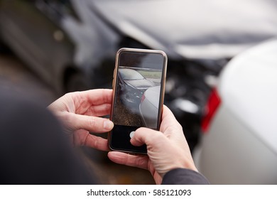 Woman Taking Photo Of Car Accident On Mobile Phone