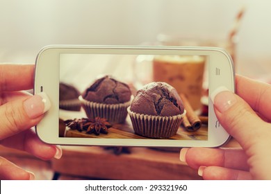 Woman taking a photo of delicious homemade chocolate muffins and ice coffee - Powered by Shutterstock