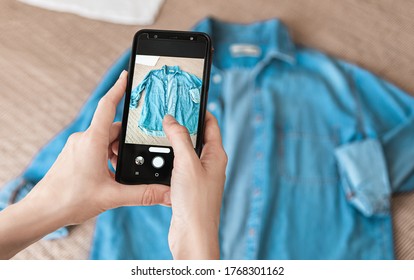 Woman taking photo of denim shirt on smartphone  - Shutterstock ID 1768301162