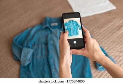 Woman taking photo of denim shirt on smartphone  - Shutterstock ID 1775844800