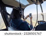 Woman Taking Photo from Helicopter In West Yellowstone Montana