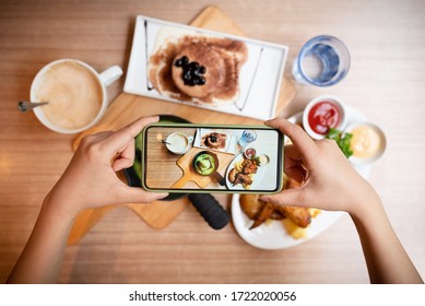 Woman was taking a photo of her food with smart phone.