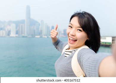 Woman taking photo her selfie in Victoria Harbor of Hong Kong