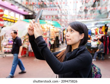 Woman taking photo in Hong Kong downtown street