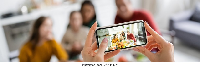 Woman Taking Photo Of Multicultural Family And Thanksgiving Dinner At Home, Banner