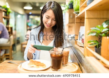 Woman taking photo on food in cafe