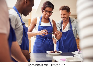 Woman Taking Photo Of Pancake Dish For Social Media In Cookery Class