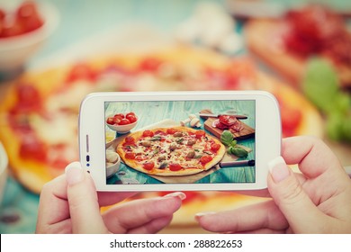 Woman taking a photo of Pizza and Ingredients with smartphone - Powered by Shutterstock