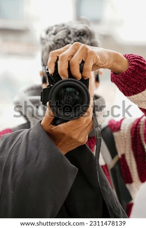 woman taking a photo with a reflex looking at camera. Photographer day in winter