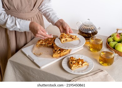 Woman taking piece of apple pie. Homemade apple pie on cutting board on a family table. Autumn baking