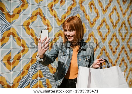 Woman taking a selfie with her shopping bags