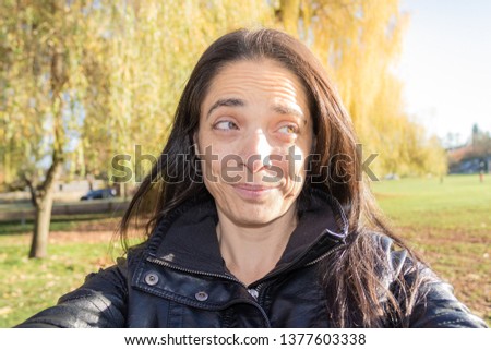 A woman taking a selfie at the park
