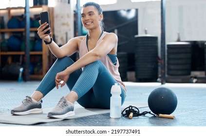 Woman Taking Selfie With Phone After Workout At The Gym, Reading Social Media Post And Relax After Cardio Fitness Exercise At Club. Athlete Girl On Mobile App For Sports While Training On Floor