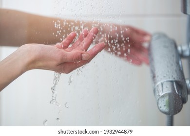 Woman taking a shower at home - female hands tryimg the temperature of water in shower - Shutterstock ID 1932944879