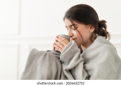 Woman taking a sip of tea from the mug during winter