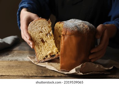 Woman taking slice of delicious Panettone cake with powdered sugar at wooden table, closeup. Traditional Italian pastry - Powered by Shutterstock