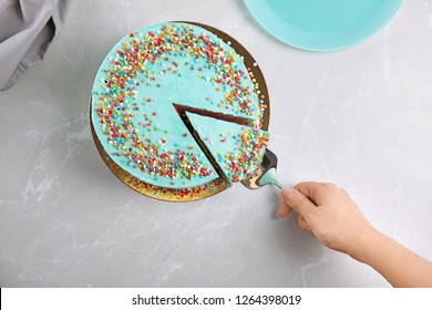 Woman Taking Slice Of Fresh Delicious Birthday Cake At Table, Top View