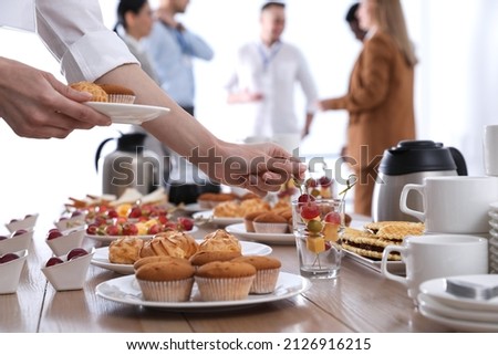 Woman taking snack during coffee break, closeup