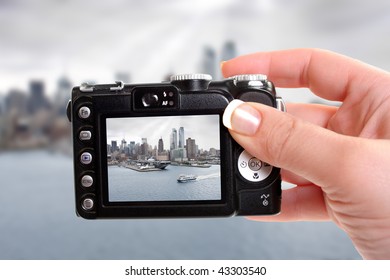  Woman taking a snapshot of the New York skyline and sea, air, space museum with an aircraft carrier along the shore of the Hudson river under dark grey skies