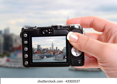 Woman taking a snapshot of  New York's famous skyline and boat docks along the Hudson River