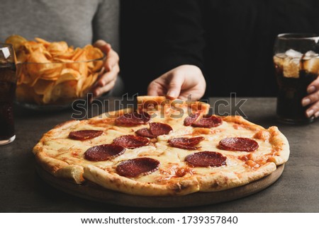 Woman taking tasty pepperoni pizza at grey table, closeup